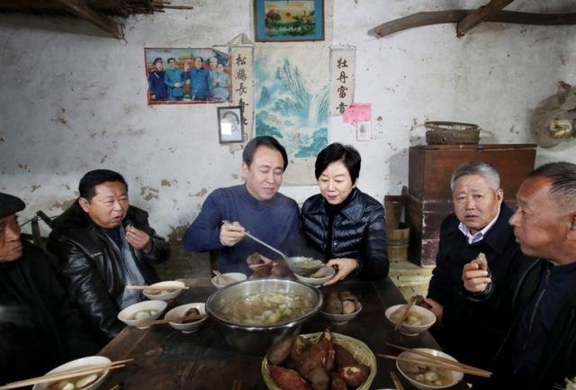 许家印夫妇在堂屋和父老乡亲一起吃忆苦思甜饭。